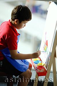 Asia Images Group - Boy sitting in front of easel, painting