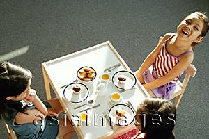 Asia Images Group - Three girls at tea party, one girl smiling at camera