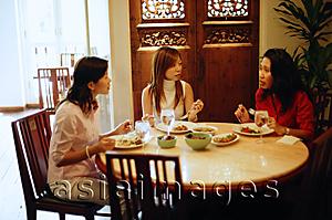 Asia Images Group - Three women having a meal at restaurant, talking