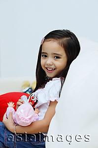 Asia Images Group - Young girl holding a doll, smiling at camera