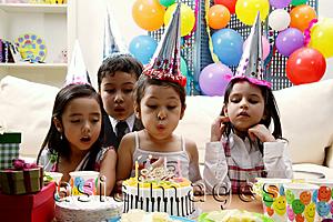 Asia Images Group - Children celebrating birthday, child blowing candles on cake