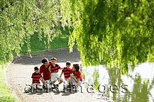 Asia Images Group - Family with three boys outdoors in park, tree branches in foreground