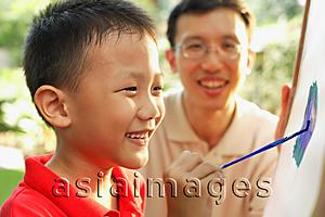 Asia Images Group - Boy drawing on easel, father watching