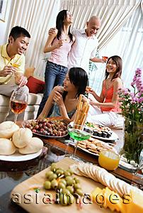 Asia Images Group - Adults in living room, having party