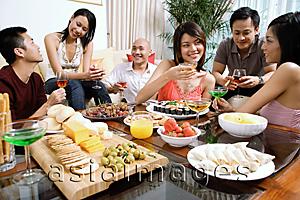 Asia Images Group - Adults having a party in living room, food on coffee table