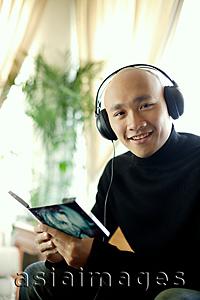 Asia Images Group - Man in black turtleneck, wearing earphones, looking at camera