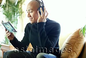 Asia Images Group - Man in black turtleneck, with headphones, listening to music