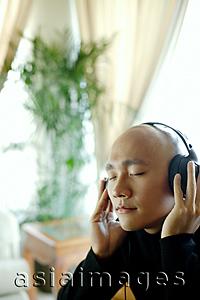 Asia Images Group - Man with headphones, listening to music, eyes closed