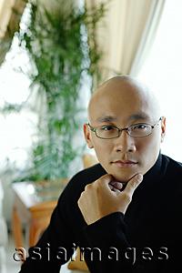 Asia Images Group - Man in black turtleneck, looking at camera, hand on chin