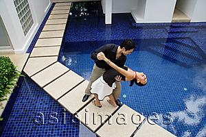 Asia Images Group - Couple by swimming pool, dancing, man dipping woman