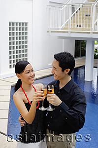 Asia Images Group - Couple by poolside, toasting with champagne