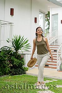 Asia Images Group - Woman walking in garden