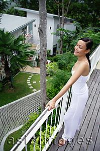 Asia Images Group - Young woman holding railing, looking out at view