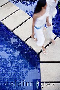 Asia Images Group - Couple walking across swimming pool