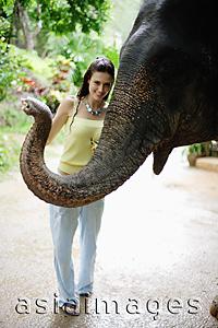 Asia Images Group - Young woman posing with elephant, looking at camera, Phuket, Thailand