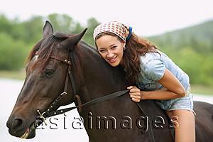 Asia Images Group - Woman sitting on horse, leaning down, smiling