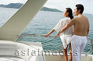 Asia Images Group - Couple standing on stern of yacht