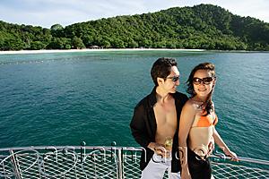 Asia Images Group - Couple on boat deck, standing next to railing