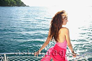 Asia Images Group - Woman on boat, standing next to railing, side view