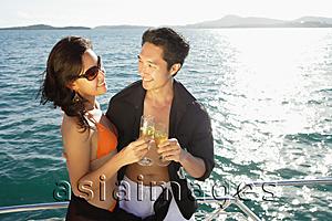 Asia Images Group - Couple on boat, holding champagne glasses, toasting