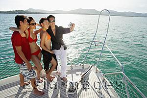 Asia Images Group - Young adults on boat deck, taking a picture