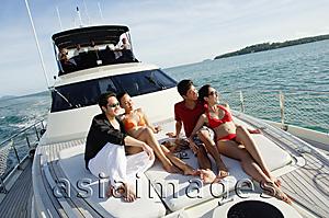 Asia Images Group - Young adults sitting on boat deck, looking away