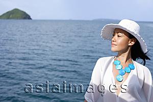Asia Images Group - Woman wearing white hat, ocean behind her
