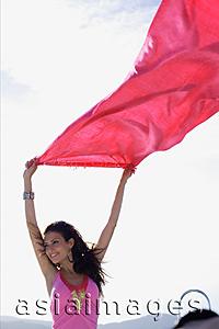 Asia Images Group - Young woman holding piece of cloth in the air, smiling