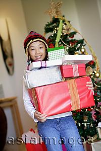 Asia Images Group - Girl holding pile of Christmas gifts