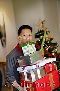 Asia Images Group - Man carrying pile of gifts