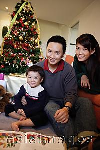 Asia Images Group - Family with one child, sitting by Christmas tree, smiling