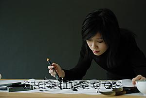 Asia Images Group - Woman painting Chinese calligraphy