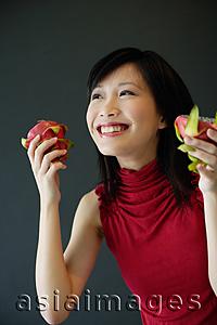 Asia Images Group - Woman holding cut dragon fruit