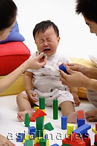 Asia Images Group - Family with one child, baby crying, parents trying to pacify him with toys