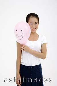 Asia Images Group - Woman holding pink balloon, smiling