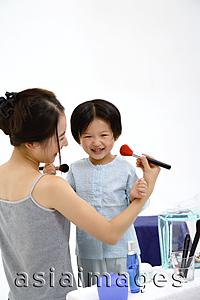Asia Images Group - Mother and young daughter applying make-up