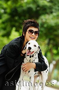 Asia Images Group - Woman with sunglasses embracing Dalmatian