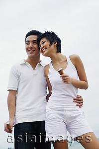 Asia Images Group - Couple standing, embracing, holding ice cream cones