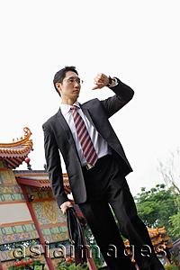 Asia Images Group - Businessman with briefcase, looking at watch