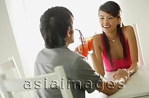 Asia Images Group - Couple toasting with drinks, sitting face to face, holding hands