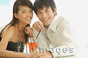 Asia Images Group - Couple with a drink between them, smiling at camera