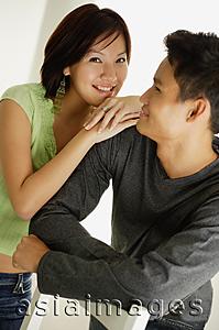 Asia Images Group - Man leaning arms on back of chair, looking at woman leaning on his shoulder