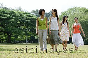 Asia Images Group - Four young women walking across field