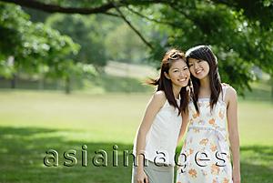 Asia Images Group - Two young women standing side by side, cheek to cheek