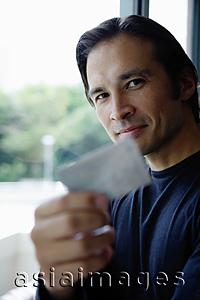 Asia Images Group - Man holding credit card, smiling at camera