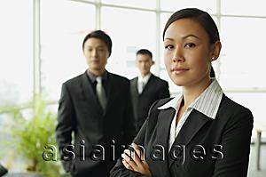 Asia Images Group - Businesswoman looking at camera, two businessman in the background