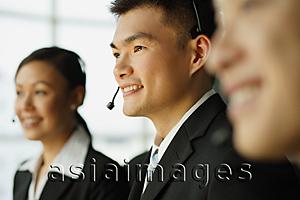 Asia Images Group - Customer service officers, in a row, focus on man in the middle