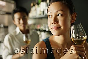 Asia Images Group - Woman holding a drink, man in background