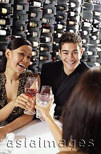 Asia Images Group - Young adults in restaurant, holding wine glasses, toasting