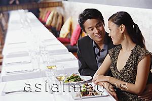 Asia Images Group - Couple in restaurant, sitting side by side, looking at each other